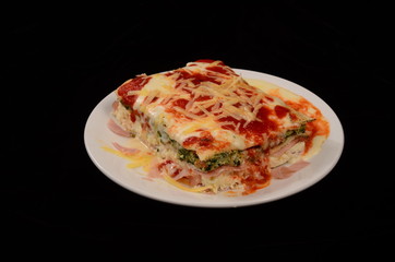 Lasaña con queso, salsa pomodoro y rellena de verdura espinaca y jamón