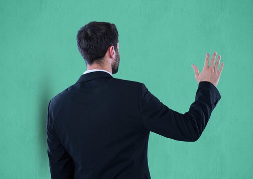 Rear view of businessman gesturing over green background