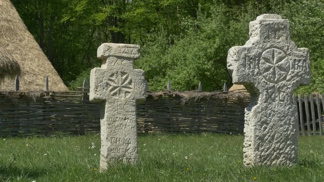 Ancient stone Romanian orthodox crosses in a rural area.