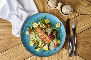 Vegetable salad with cucumber, lettuce, cherry tomatoes, salmon and eggs