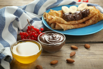 Honey and chocolate for tasty pancakes on table