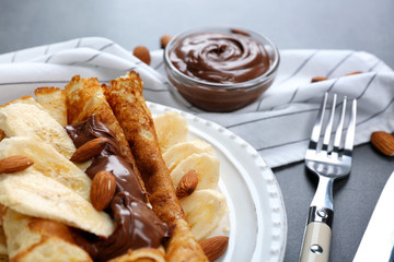 Delicious pancakes with chocolate and banana on white plate