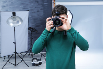 Obraz premium Young professional photographer with camera in studio