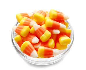 Colorful Halloween candy corns in bowl on white background