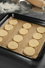 Raw dough for cookies on baking tray, closeup