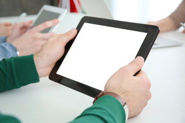 Man sitting at table in office and using tablet
