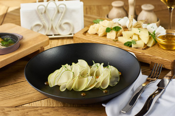 Ceviche of whitefish, cheeseplate, soup with meatballs and glass of white wine served on wooden table in restaurant