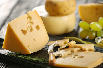 Tasty cheese on wooden board, closeup