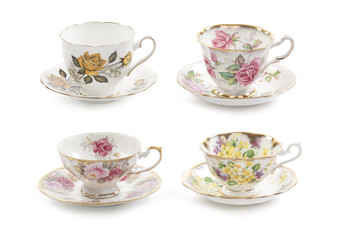 High resolution close-up of four beautiful antique tea cups with saucers isolated on a white...