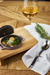 Potato soup with meatballs served on wooden table with spoon and glass of wine