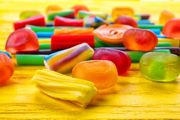 Tasty jelly candies on wooden background, closeup