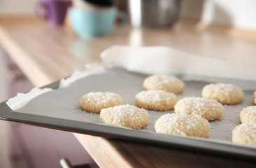 Baking tray with coconut cookies on table, closeup