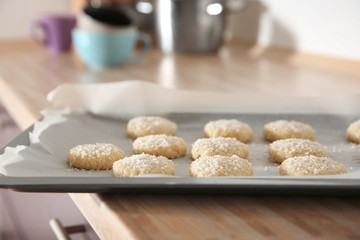 Baking tray with coconut cookies on table, closeup