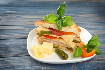 Tasty sandwich with cheese and sausage on plate