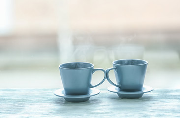 Cups with hot tea on wooden table against blurred background