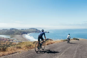 Foto auf Acrylglas Sport Gruppe von Radfahrern, Teamkollegen, Freunden, absteigende windige schmale Straße neben der Bucht mit Nebel und Wasser und blauem Himmel San Francisco in Nordkalifornien.