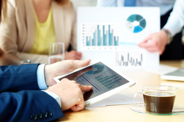 Business colleagues working and analyzing financial figures on a graphs