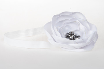 White satin flower on an elastic headband, decoration for girls on special occasions