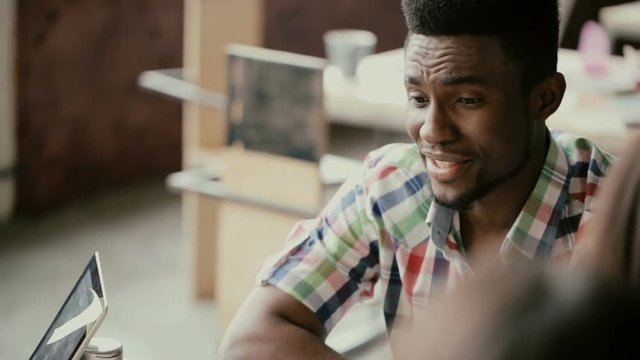 Young african businessman talking to small group of people. Handsome man does the project presentation, gives direction.