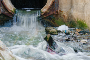 Fototapeta na wymiar Pollution drain flowing stream to a canal.