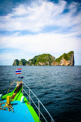 Great and large rocks in the ocean. Small islands with green forest and palms. Blue sky with...