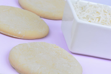 Ceramic bowl with cheese and dough on table