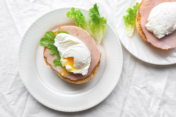 Two poached egg on a bread with salad and beef meat. Top view photo. Healthy breakfast. 