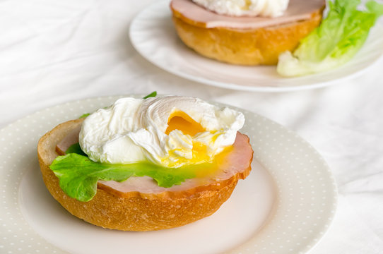 Poached egg on a bread with salad and beef meat. Healthy english toast. 