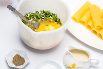 Spinach and cheese cannelloni preparation : Adding egg to the spinach and cheese filling