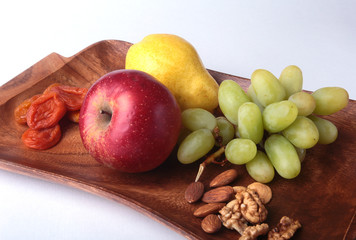 Fresh organic fruits on wood Serving tray. Assorted apple, pear, grapes, dried fruits and nuts.