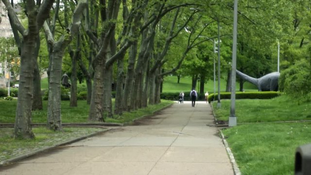 Establishing daytime shot of sidewalk outside of museum with brontosaurus or apatosaurus statue