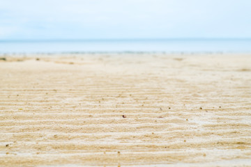 Close up beach sand with blur sea at background