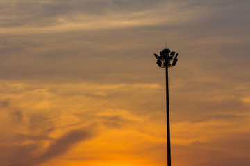 silhouette stadium spotlight on the orange evening sky