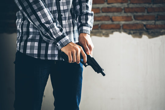 Robber holding a gun. Low key photo and selective focus. criminality concept.