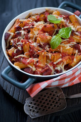 Baking dish with italian traditional ziti, closeup, selective focus, studio shot