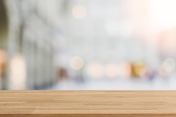 Wood table top and blurred shopping plaza background - can used for display or montage your...