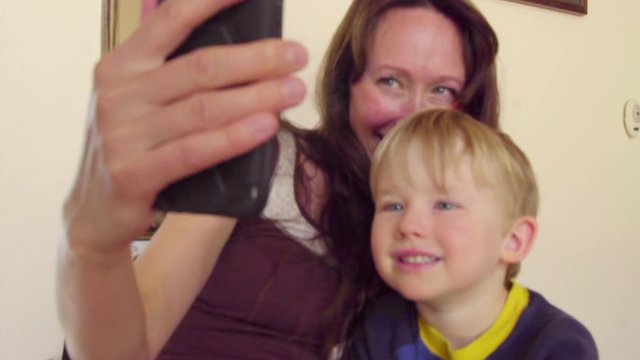 Adorable mom and son take selfie with phone