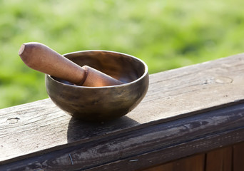 closeup of a tibetan singing bowl with its mallet 
