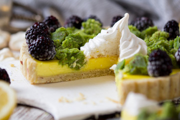 Delicious homemade lemon tart. Pie on rustic white table. Tart with blackberry and meringue