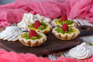 Delicious homemade lemon tart. Pie on rustic white table. Tart with raspberries and meringue