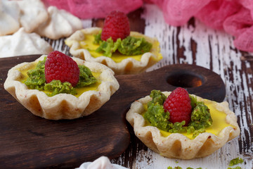 Delicious homemade lemon tart. Pie on rustic white table. Tart with raspberries and meringue