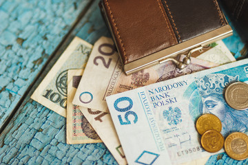 Polish zloty with little wallets on the old wooden background