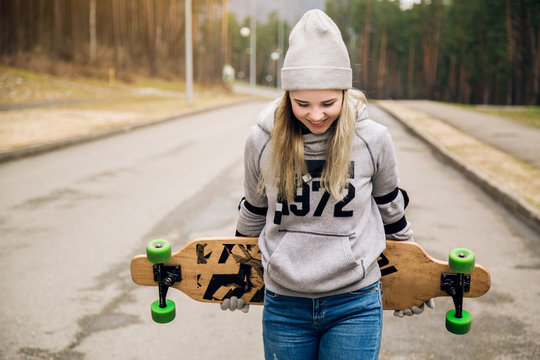 sporty young girl with a longboard