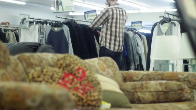 Man in thrift store shops for some new shirts