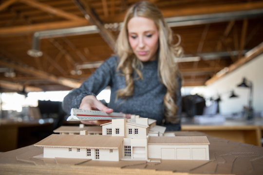 New career creative professional woman in architectural office taking measurements of building - Powered by Adobe