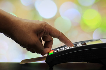 Male hand enters PIN code on payment terminal