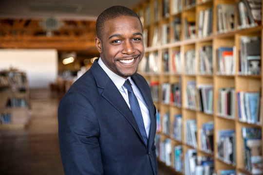 Happy smile from handsome african american legal professional at office firm hall with bookshelves