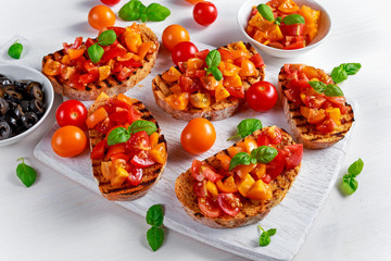 Tasty Traditional Tomato bruschetta with fresh basil on white board