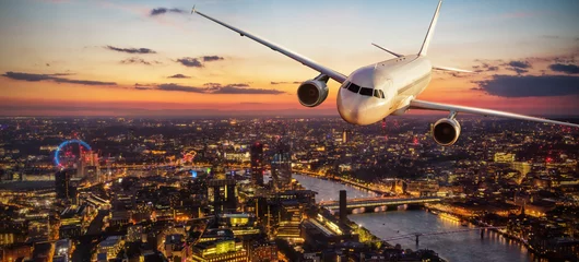 Deurstickers Passagiersvliegtuig dat boven de stad van Londen in het zonsonderganglicht vliegt © Jag_cz
