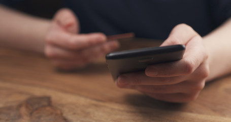 young female teen hand using smatphone sitting at the table closeup, 4k photo